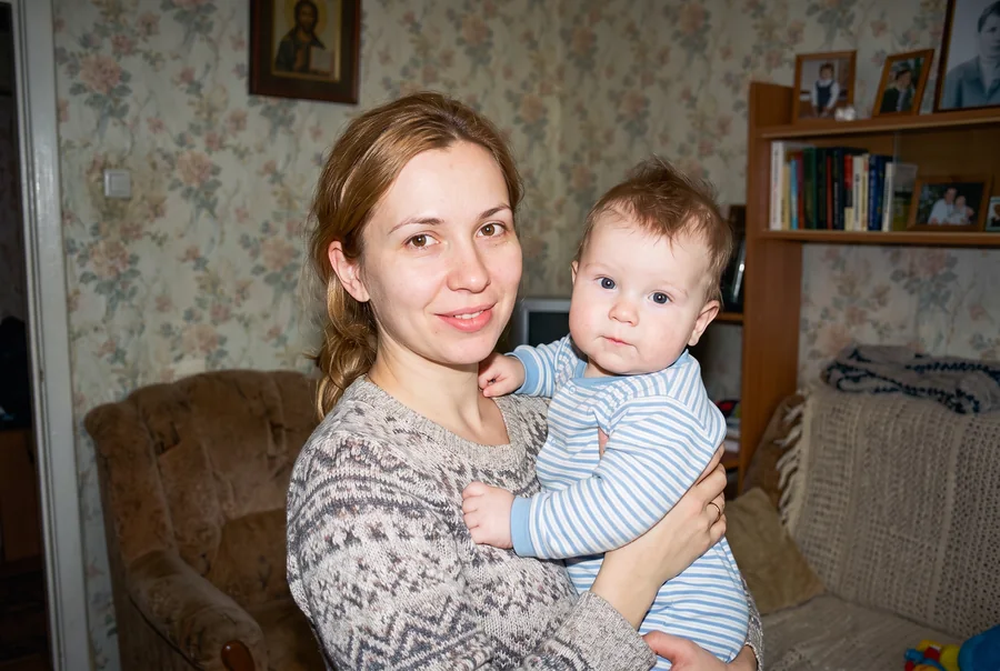 Младенец на руках у мамы, кадр цифровой мыльницы 2008 года, подобранный как детство именинника