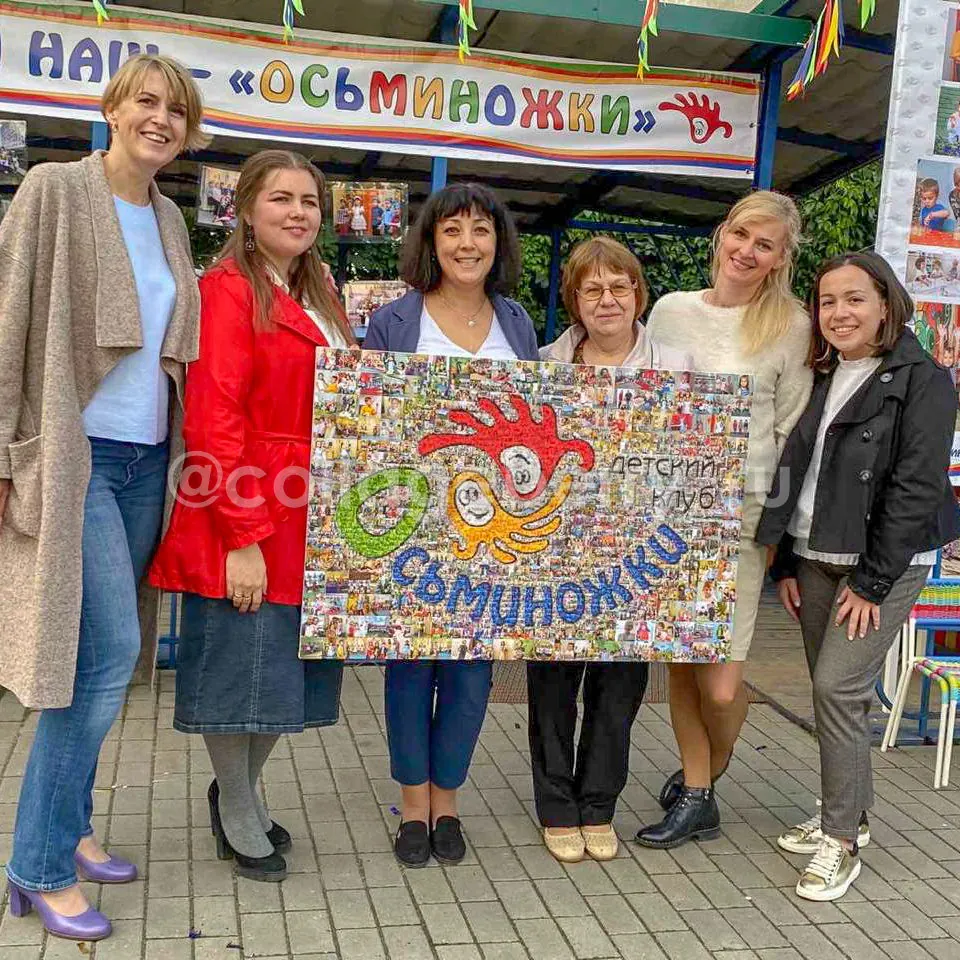 Воспитатели детского сада с фотомозаикой-логотипом группы